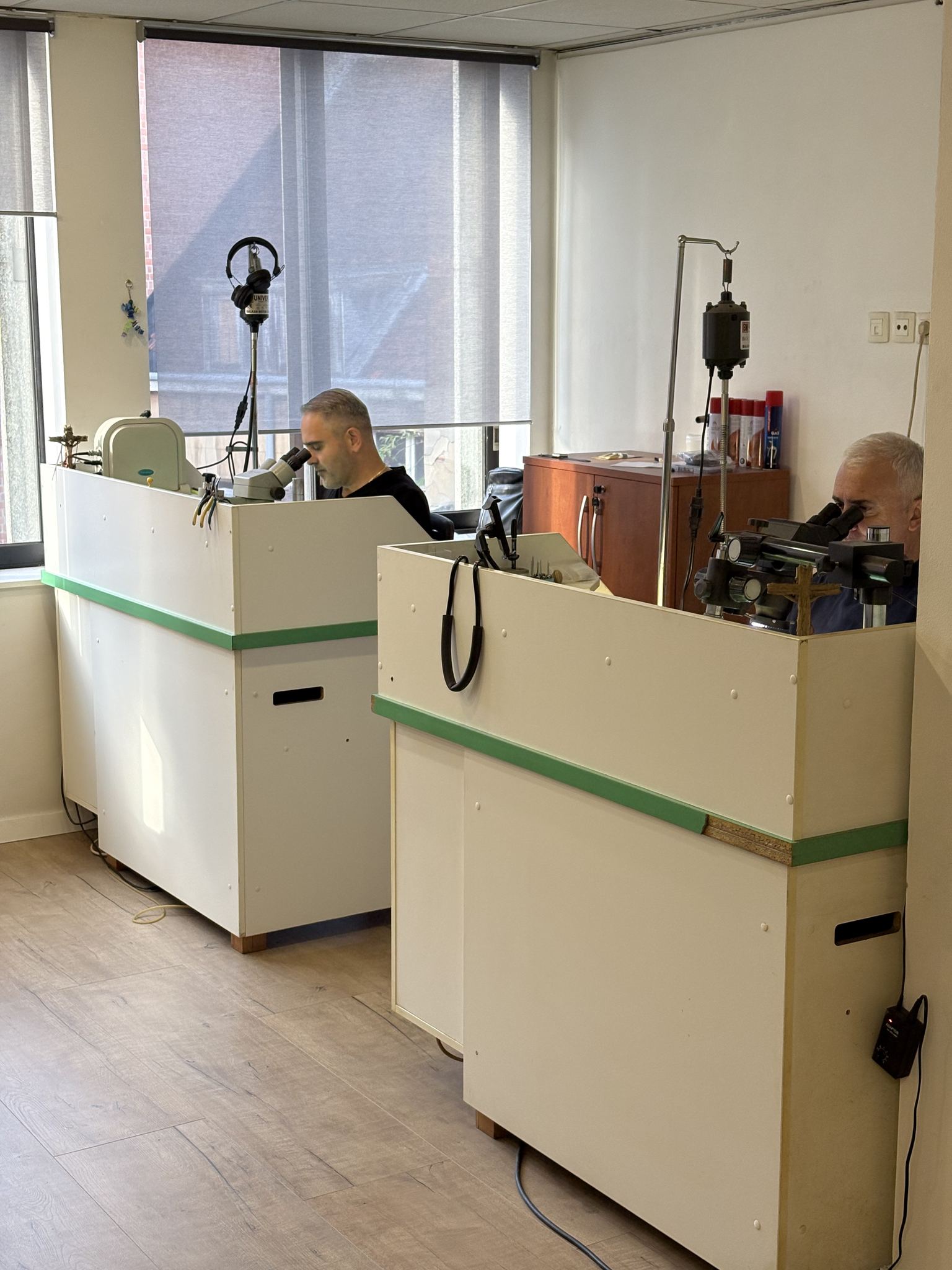 Sertisseurs à l'ouvrage sous loupe binoculaire — atelier SKJ Serti, Anvers