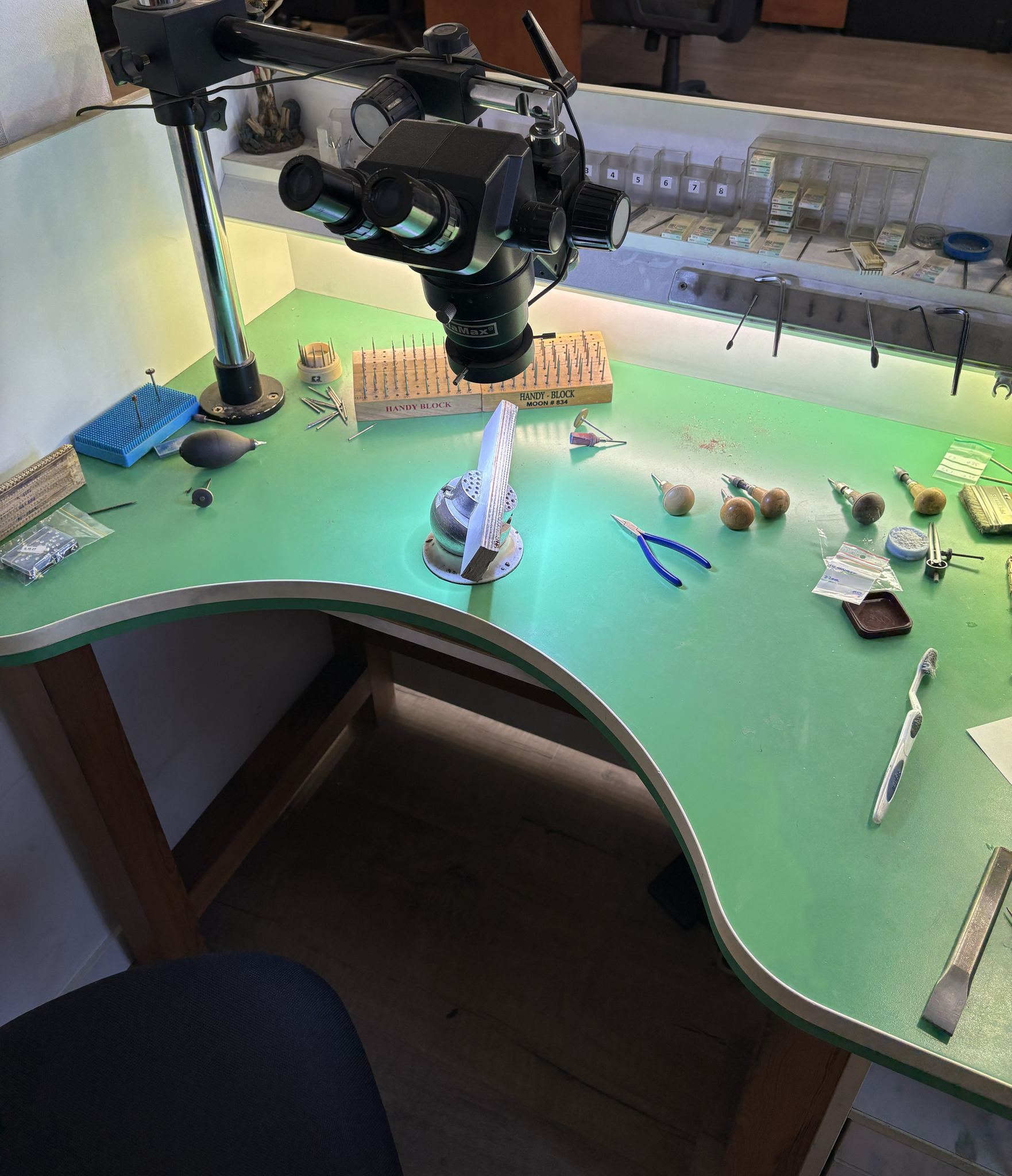 Établi de sertissage vu de dessus, outils et loupe binoculaire — atelier SKJ Serti, Anvers